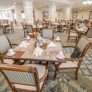 An elegantly set dining area with neatly arranged tables and chairs.
