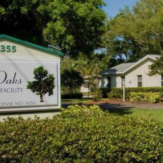 Entrance to a residential community with a sign and well-maintained landscaping.