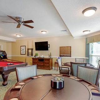 A cozy game room featuring a pool table, poker table, and a television.