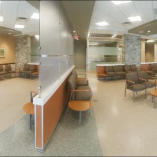 A modern hospital waiting room with comfortable seating and neutral tones.