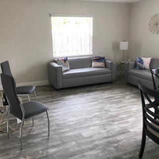 A modern living room with gray couches and chairs on a stylish floor.