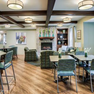 A modern lounge area featuring comfortable seating, a fireplace, and elegant lighting.