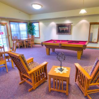 A cozy recreation room featuring a pool table and seating area.
