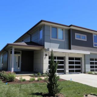 A modern two-story house with a well-maintained front yard and a double garage.