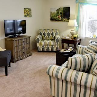 A cozy living room with striped furniture and a television.
