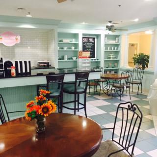 A cozy cafe interior with tables, chairs, and fresh flowers.
