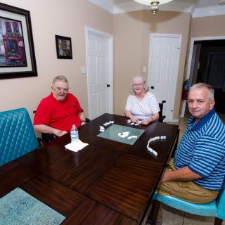 Three people sitting around a dining table in a cozy indoor setting.