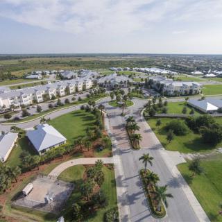 Aerial view of a campus with buildings, roads, and lush greenery.