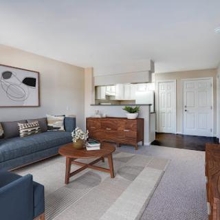 A modern living room featuring a stylish sofa, elegant coffee table, and contemporary artwork for a cozy yet chic vibe.
