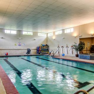 A spacious indoor swimming pool equipped for fitness and recreational activities.