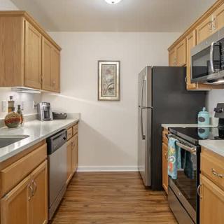 Modern kitchen with wooden cabinets and stainless steel appliances.