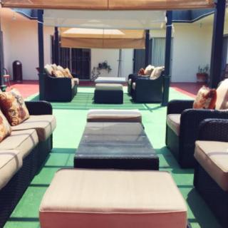 An inviting outdoor seating area with comfortable couches and a canopy overhead.