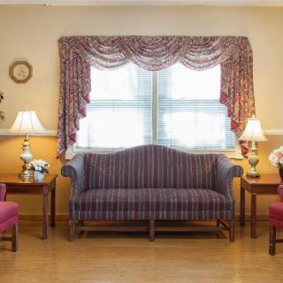 A traditional living room setup with a sofa, chairs, and decorative lamps.