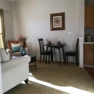 A cozy living area with a small dining table and chairs, accented by a comfortable sofa and decorative elements.