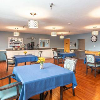 A bright and inviting dining room with blue tablecloths and modern lighting fixtures.