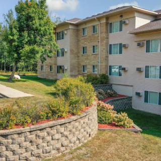A well-maintained apartment building surrounded by greenery and a landscaped garden.