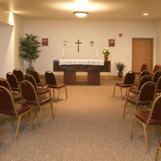A small chapel with rows of chairs facing an altar.