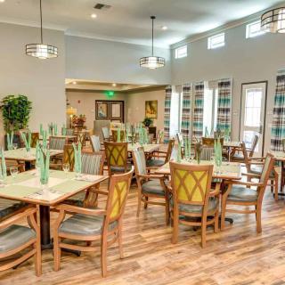 A modern dining room with neatly arranged tables and chairs, featuring contemporary lighting and decor.