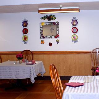Cozy restaurant interior with decorated walls and neatly set dining tables.