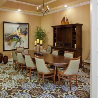 A well-decorated dining room with an elegant table set, artwork, and ambient lighting.