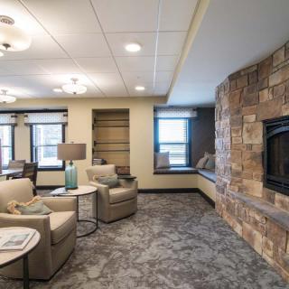 A cozy living room featuring a stone fireplace and comfortable seating.