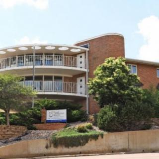 A modern apartment building with round balconies and greenery.