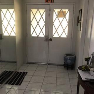 A tiled entrance area with double doors and an exit sign above.