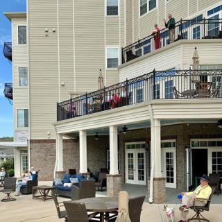 People relaxing on the patio and balconies of a residential building.