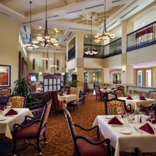 A well-decorated restaurant interior with elegant chandeliers and neatly arranged dining tables.