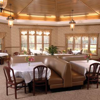 A cozy restaurant dining area featuring booths and tables with elegant lighting.