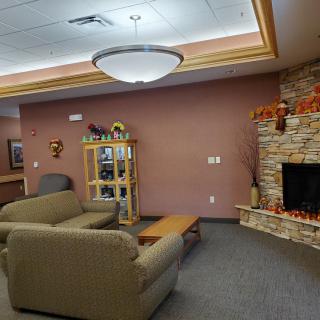 A cozy lounge area with comfortable seating and a decorative fireplace.