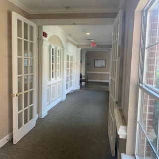 A well-lit hallway with large windows and glass doors.