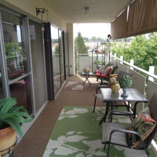 A cozy balcony with outdoor seating and greenery.