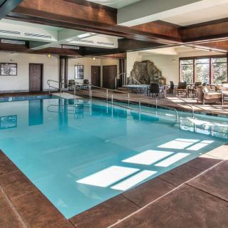 A spacious indoor swimming pool area with natural light streaming in.
