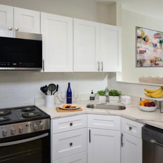 Modern kitchen interior with white cabinets and stainless steel appliances.