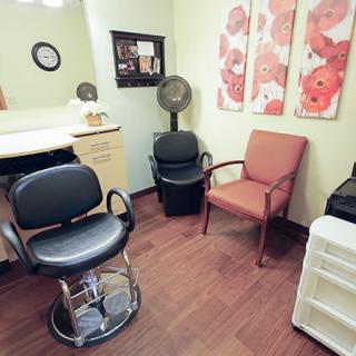 A cozy hair salon interior with chairs and a wall-mounted mirror.