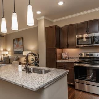 A modern kitchen with granite countertops and stainless steel appliances.