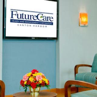 A modern healthcare waiting room featuring the FutureCare logo displayed on a television, complemented by floral decor.