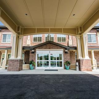 The main entrance of a building with a covered walkway and brick exterior.