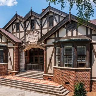 A historic Tudor-style building with a prominent entrance and brick exterior.