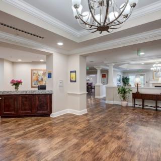 Elegant lobby area with a chandelier and wooden flooring.