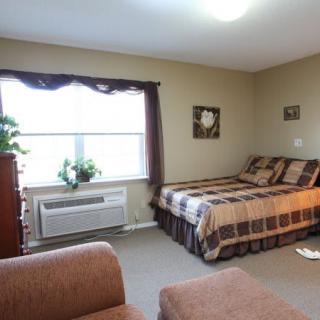 A cozy bedroom with a bed, window, and comfortable furnishings.
