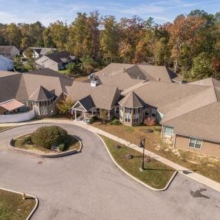 Aerial view of a residential building surrounded by trees in autumn.