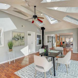 A modern dining room with skylights and a ceiling fan, featuring contemporary decor and hardwood floors.