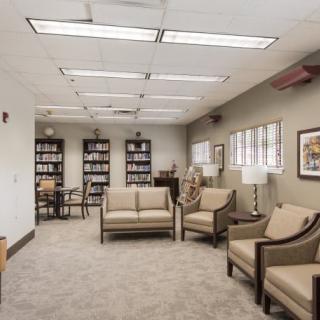 A well-lit waiting room with comfortable seating and bookshelves.