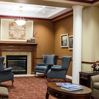 A cozy lounge area featuring armchairs, a fireplace, and elegant interior decor.