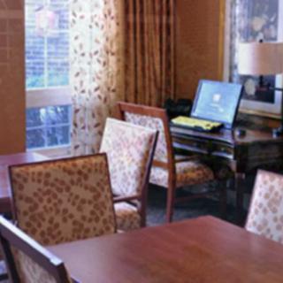 A cozy office space with wooden furniture and floral curtains.
