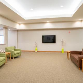 A modern lobby with comfortable seating and a wall-mounted TV.