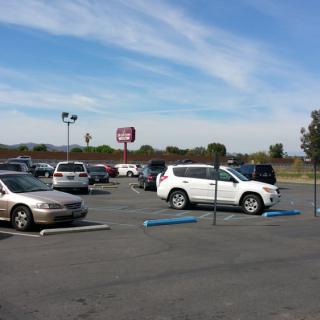 A parking lot with several cars parked under a clear blue sky.