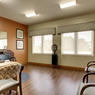 A cozy waiting area with wooden flooring and comfortable seating.